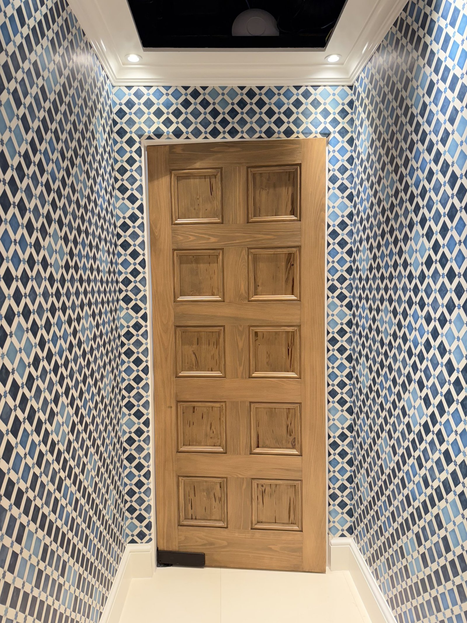 Powder room with blue geometric wallpaper in a Palm Beach residence by Salt Wallcovering
