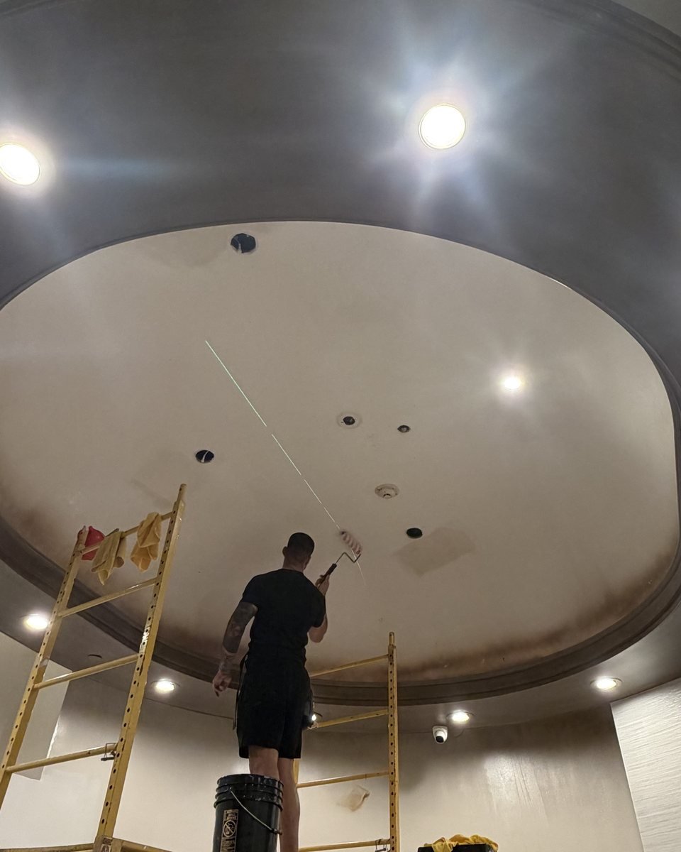 Wallcovering installation on a domed ceiling from scaffolding