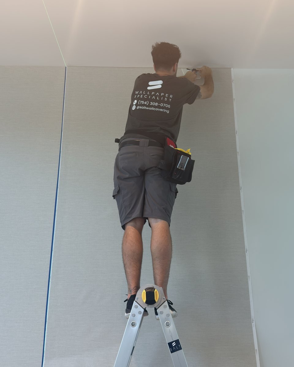 Wallcovering installer hanging a panel with careful seam alignment